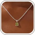 Close-up detail of teardrop green zircon pendant necklace with delicate silver box chain. - 14k / August-Silver