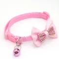 Cute pink pet collar close-up, featuring a plaid bow and a metallic bell for cats. - Pink