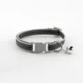 Detailed view of the black and grey woven pet collar featuring a durable plastic buckle. - Black