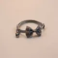 Detailed view of the grey polka dot pet collar, featuring a cute bow and a jingling bell. - Gray