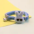 Detailed view of cute blue plush pet collar featuring a rabbit with sunglasses and a bell. - Blue