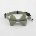 Close-up detail of light green pet cat collar with cute bow tie and metallic bell attachment. - Grey Green