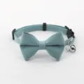 Close up detail of cute blue bowknot pet cat collar featuring a shiny metal bell and buckle. - Blue