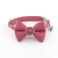 Close-up detail of pink pet cat dog collar with fabric bow, rhinestone ring, and metal bell. - Bowknot Choker / Watermelon red