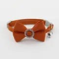 Orange pet collar detail showcasing rhinestone bowknot embellishment and silver bell pendant closeup - Bowknot Choker / Caramel color