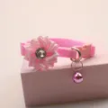 Close-up detail of the pink pet collar featuring a ribbon flower, crystal, and a hanging bell. - 1.0cm / Pink