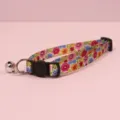 Floral cat collar detail shot featuring safety buckle and metal bell accessory - Blue Red Yellow