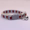 Close-up detail of cute blue apple pattern pet cat collar with lace and bell for dogs. - Blue Base Red Apple