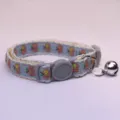 Cute blue apple embroidered pet collar detail closeup with metal bell and plastic buckle. - Blue Base Pink Apple