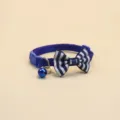Vue détaillée du collier pour chat à rayures bleues avec nœud papillon, cloche et boucle. - Bleu saphir