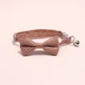 Close-up detail shot of the pet collar bow tie, showing the striped texture and metal bell. - Dark Pink