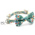 Floral cat collar detail showing green bow, metal bell, and secure plastic buckle. - Green Floral