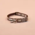 Close-up detail of a charming floral cat collar with a cute silver bell and safety buckle. - Coffee
