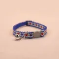 Close-up detail of blue floral pet collar with safety buckle and bell, neat stitching. - Sapphire Blue