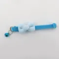 Gedetailleerd detail van een zachte blauwe pluche huisdierenhalsband met bel en versteller. - Hemelsblauw