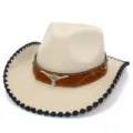 Primer plano detallado del sombrero de vaquero western con accesorio de toro y borde negro. - Beige