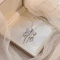 Primer plano de un collar con colgante de mariposa de circonita plateada en una caja elegante. - X1462-Mariposa color acero