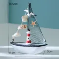Primo piano dettagliato dell'ornamento di mini barca a vela con faro e conchiglie. - Barca Faro Gabbiano Conchiglia