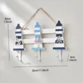 Colgador de pared de madera estilo mediterráneo con tres faros y ganchos metálicos para decoración. - Gancho de Faro Triple