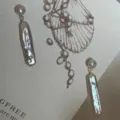 Primer plano detallado de pendientes de perla barroca natural con perno de plata. - Pendientes de Color Plata Pura