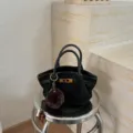 Stylish black fashion top handle tote handbag with metallic turn lock and cute charm. - Black