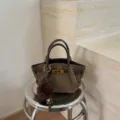 Detail view of the elegant brown suede bucket bag with metal clasp and fluffy pom-pom. - No Pendant / 16x8x15 / Green