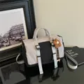 Vista dettagliata della borsa a tracolla casual bicolore elegante con ciondolo floreale. - Nero