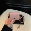 Mini sac bandoulière en suédine rose avec fermoir pression et lanière perlée. Chic et décontracté. - Rose