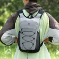 Detailed view of the lightweight outdoor casual backpack featuring mesh side pockets and bungee cords. - Gray
