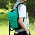 Lightweight green outdoor hiking backpack for travel and sports, worn by model in nature. - Green