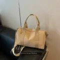 Close-up detail van de casual beige nylon crossbody shopper met dubbele handvatten. - Khaki