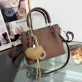 Elegante borsa a mano marrone con tracolla regolabile e ciondolo a cuore intrecciato. - Con Ciondolo / Marrone Con Ciondolo