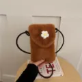Detailed view of the brown plush phone bag with cute white crochet flower and strap. - Brown