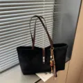Bolso tote negro minimalista para mujer con asas marrones, ideal para el trabajo diario. - Con Colgante / Negro