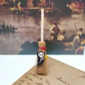 Close-up detail of mini Halloween witch broom hanging ornament with grim reaper skull charm craft. - 10cm / Black Ghost