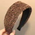 Gros plan sur le serre-tête large plissé marron avec un motif à pois sombres. - Marron