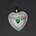 Pendentif cœur en cristal blanc exquis avec zircon vert dans un serti doré, vue détaillée. - Cristal blanc