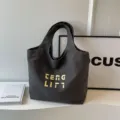 Dunkelgraue Segeltuchtasche mit gelben Stickbuchstaben, stilvolle minimalistische Damentasche. - Schwarz