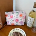 Detailed view of the pink floral makeup pouch showcasing vibrant floral patterns and label. - Soft Pink Floral - Large