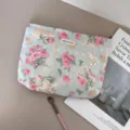 Detailed view of vintage angel and rose pattern cosmetic bag featuring soft fabric and woven label. - Rose Angel Story