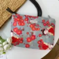 Detailed view of traditional Chinese style cartoon makeup pouch with floral and maiden print. - Begonia Lady
