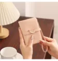 Minimalist pink leather short wallet for women featuring leaf buckle and handy wrist strap. - Pink