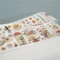 Decoratieve PET washi tape rol met leuke taarten en bloemen voor creatieve knutselprojecten. - Sweet Cups (rol transparante glitterfolie) / Volle Rol