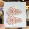 Gedetailleerd close-up van roze bloem acryl ekenbek haarspelden met schattig madeliefje patroon. - Rozerood