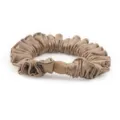Detailed view of luxury champagne silk satin scrunchie with pleated design and elegant bead. - Light Coffee
