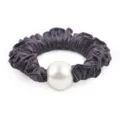 Close up detail shot of elegant dark purple satin hair scrunchie with large white faux pearl. - Deep purple