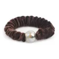 Close-up detail of a brown velvet hair scrunchie featuring a shiny decorative bead accent. - Dark Brown