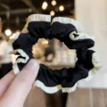 Black and white pleated hair scrunchie detail view, elegant fabric hair accessory for women. - Black With Beige Edge