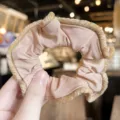 Close-up detail of vintage velvet lace hair scrunchie, elegant nude brown elastic hair tie. - Pink