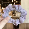 Light purple satin ruffled hair scrunchie close-up, cute elegant hair accessory for women. - Purple